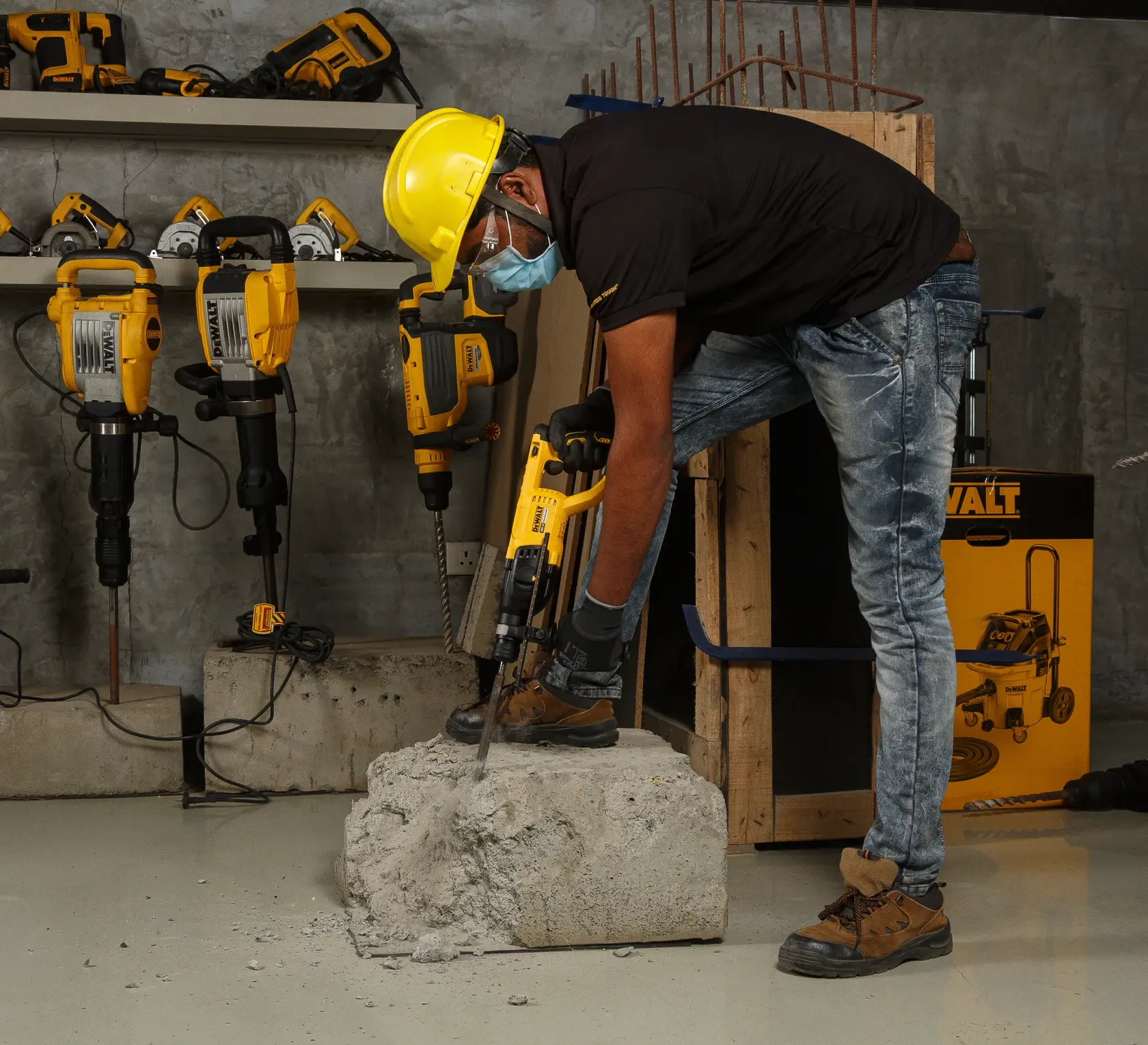 Photo of DEWALT rotary hammer DCH133NT, DCH133NT-XJ, DCH133N-XJ drilling concrete in workshop, tools visible.