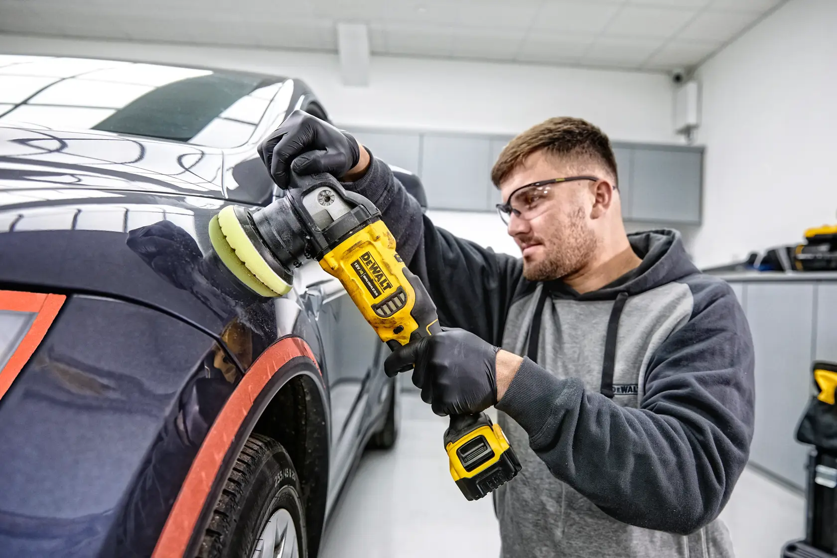DEWALT 20V Max XR brushless cordless polisher with ergonomic handle, ideal for automotive professionals. Features include a speed range of 2,000-5,500 OPM, a 5-inch hook & loop pad, and a 2.1-inch orbit diameter.