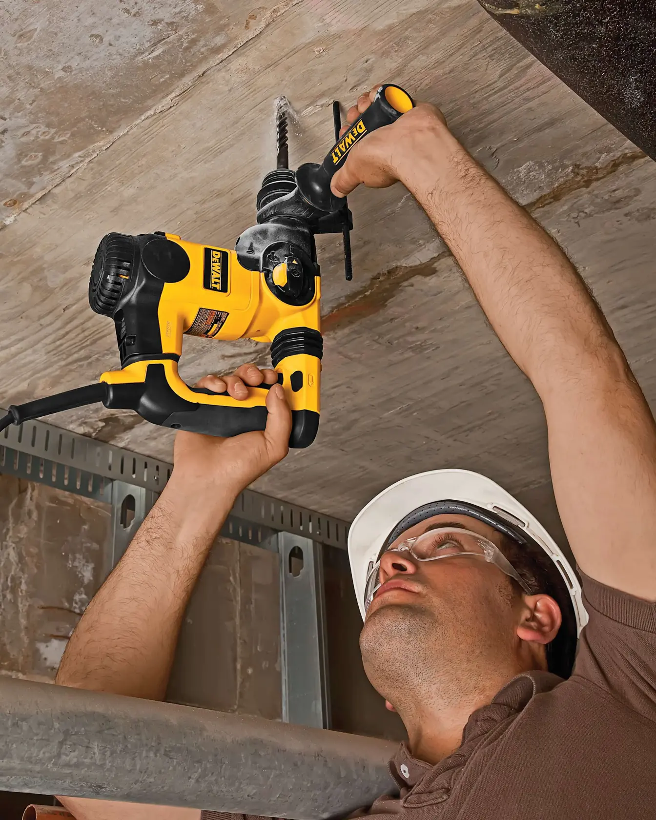 Trabajador perfora techo con DEWALT, SKUs DT9541, DT9541-QZ. Obra de construcción.