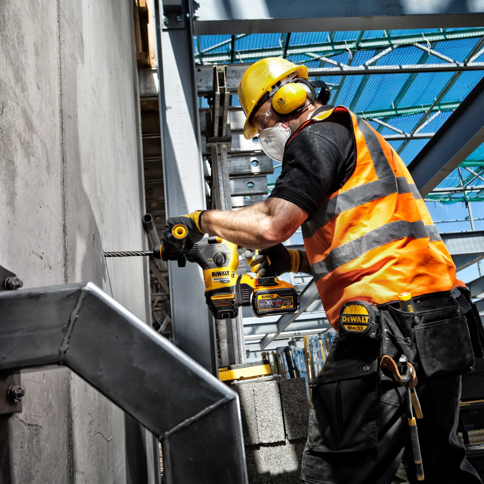Trabajador usa DEWALT DT9580, DT9580-QZ taladro en construcción con equipo de seguridad.