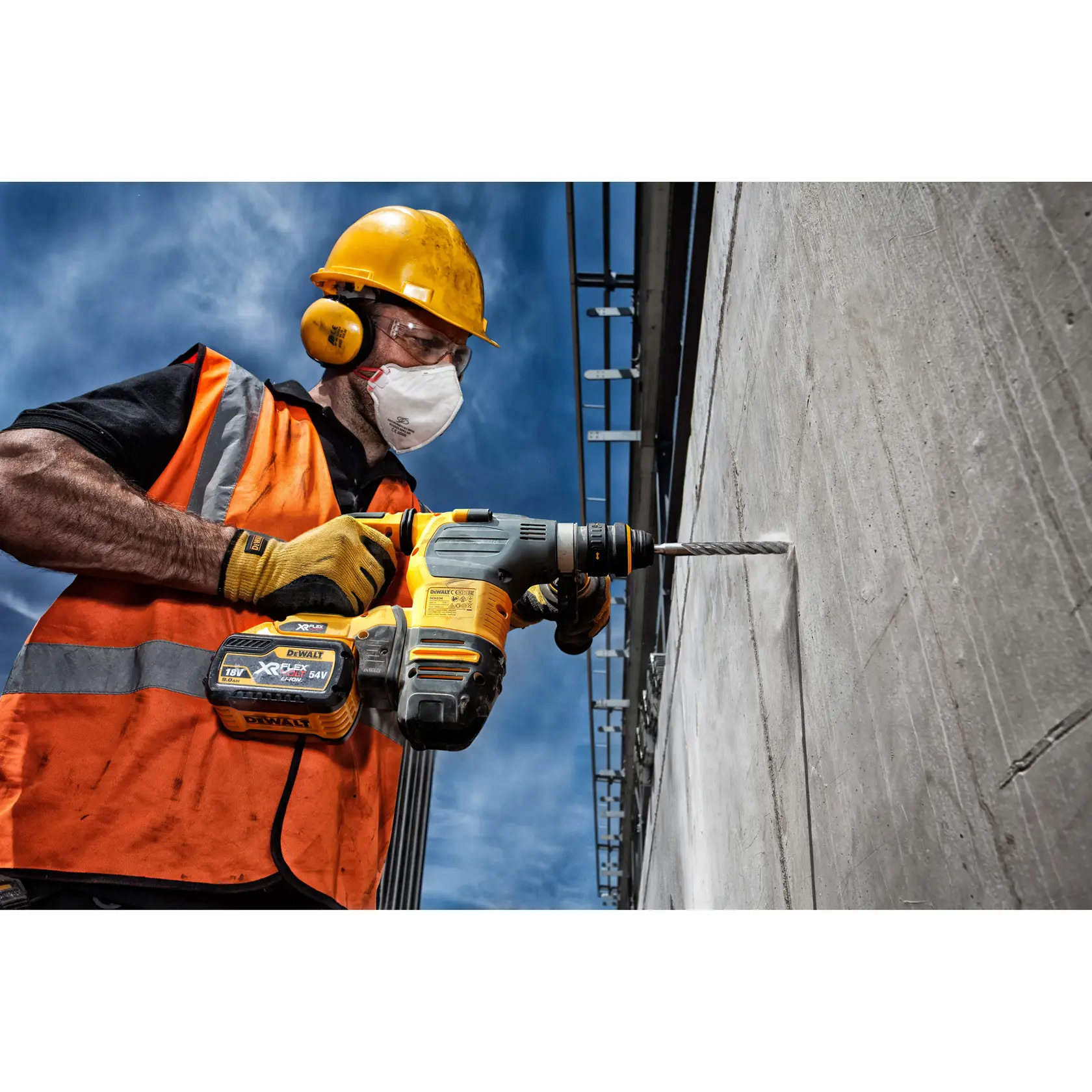 Trabajador perfora pared de concreto con taladro inalámbrico DEWALT en obra.